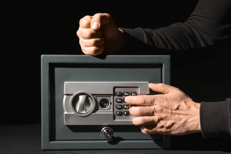 A locksmith technician entering a code on a keypad to open a locked safe for a customer