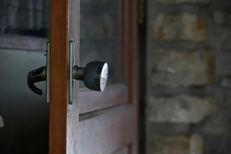 Close-up of a wood front door lock and handle, the type of residential entry door we open during a home lockout